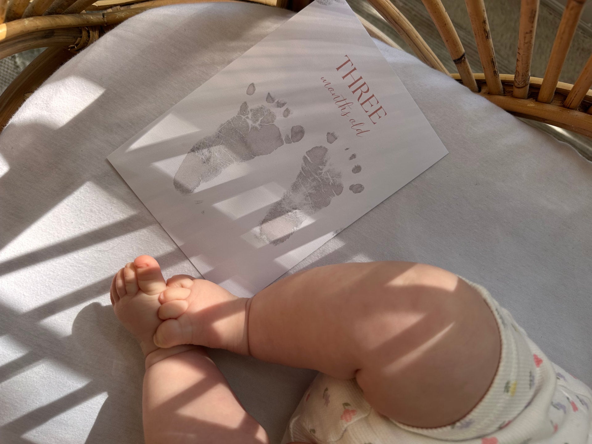 A baby's foot beside an Ari & Me keepsake card